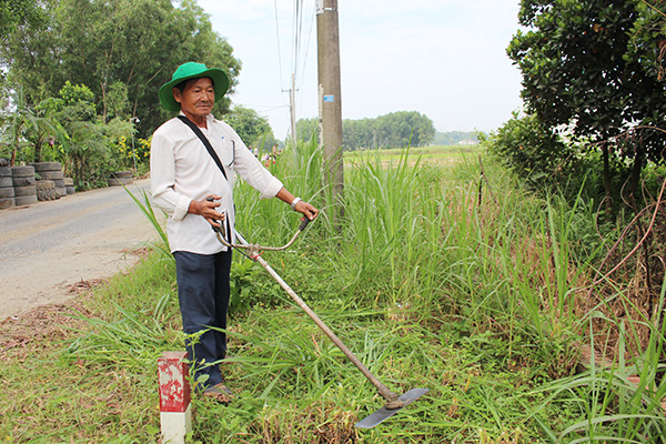 Ông Ba Đức thường xuyên dọn cỏ ven các con đường ở ấp Bình Thạch, xã Bình Hòa (huyện Vĩnh Cửu)