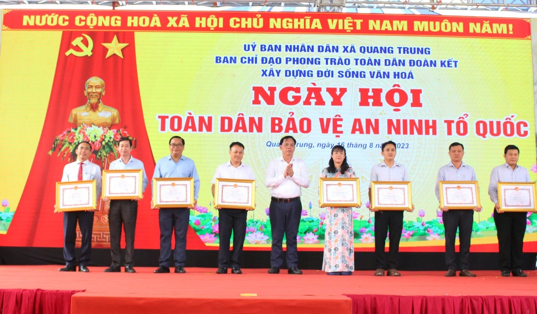 A group of people on a stage holding certificatesDescription automatically generated