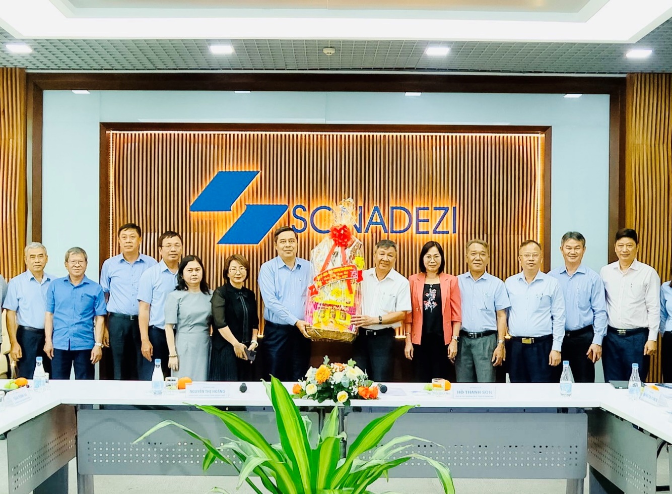A group of people standing in front of a signDescription automatically generated