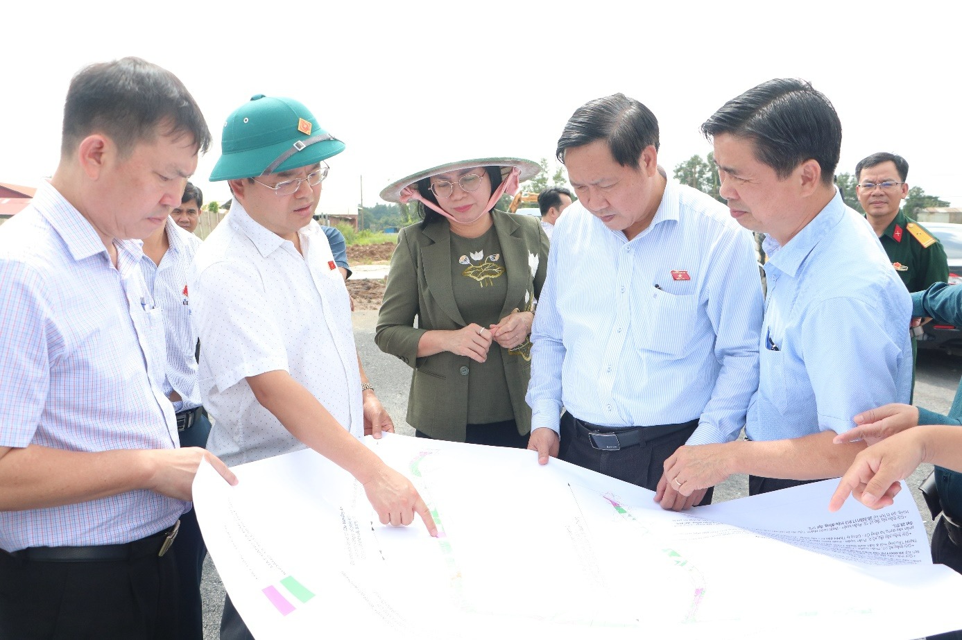 A group of people looking at a mapDescription automatically generated