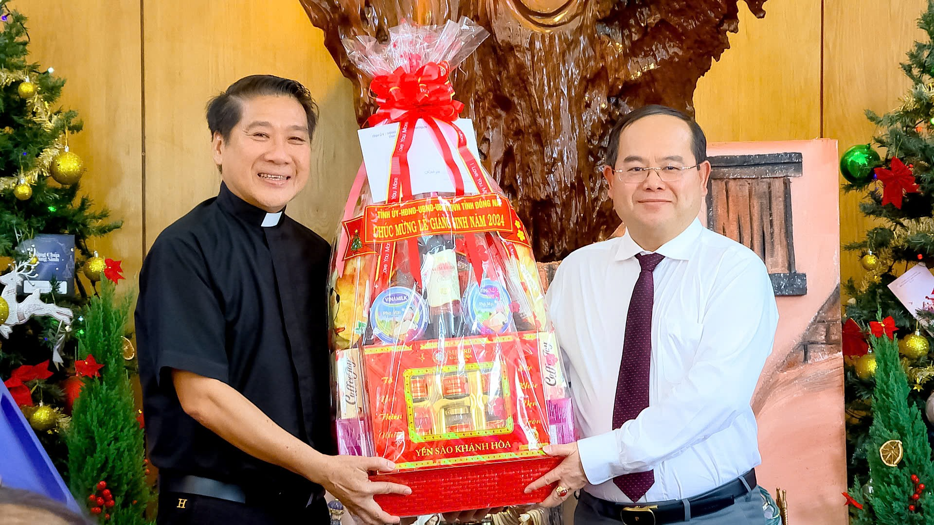 Two men holding a large bag of candyDescription automatically generated