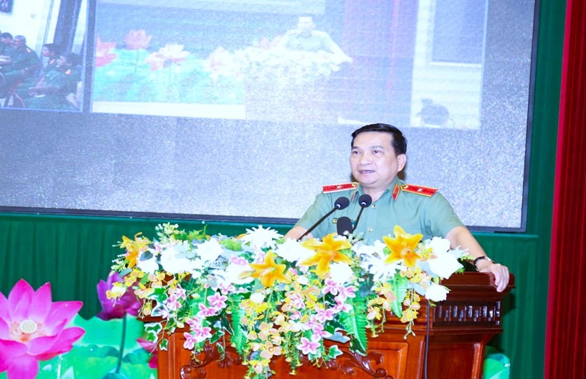 A person in uniform standing at a podium with flowersDescription automatically generated