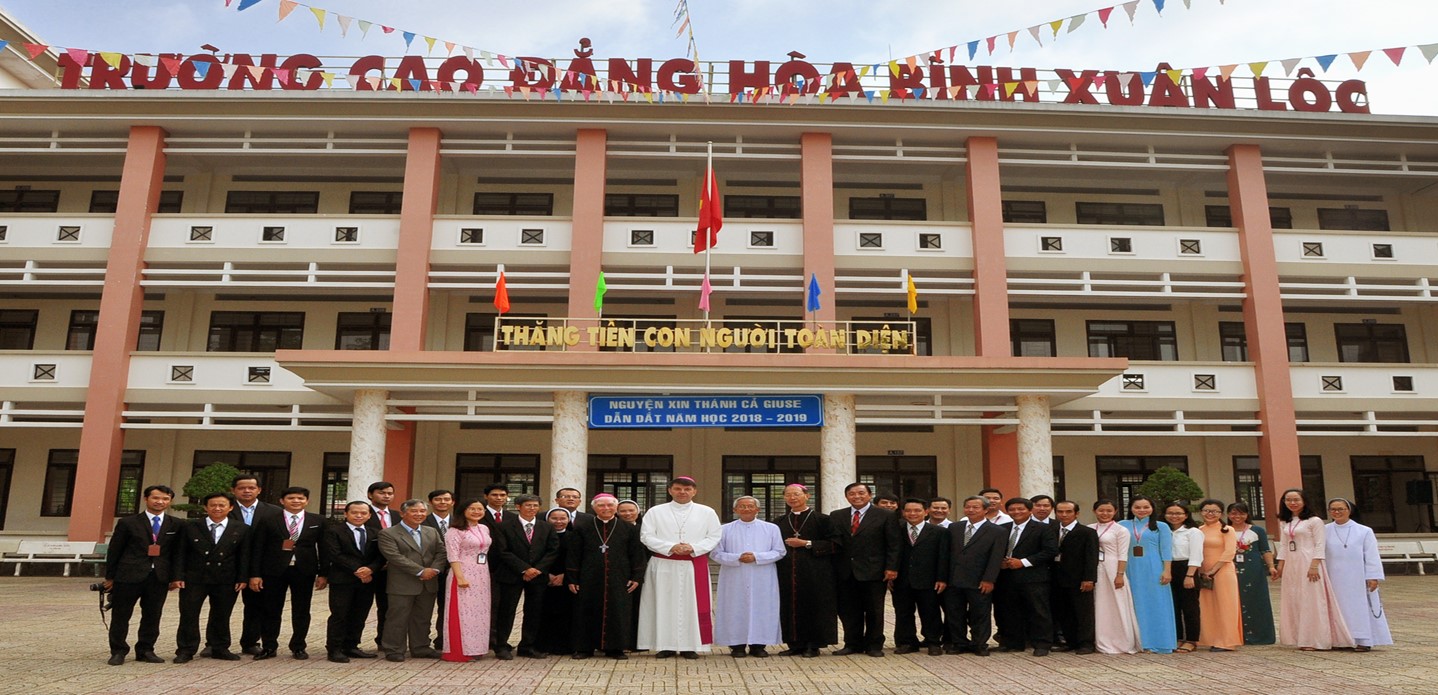 A group of people standing in front of a buildingDescription automatically generated