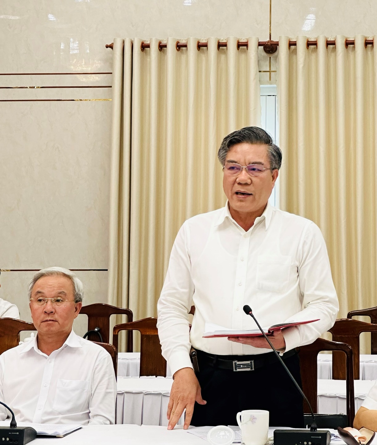 A person standing in front of a microphoneDescription automatically generated