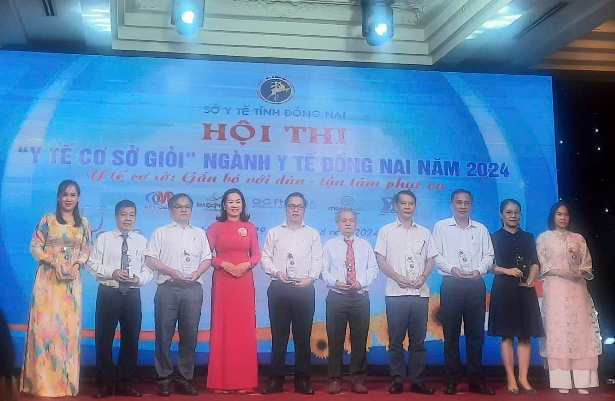 A group of people standing in front of a bannerDescription automatically generated