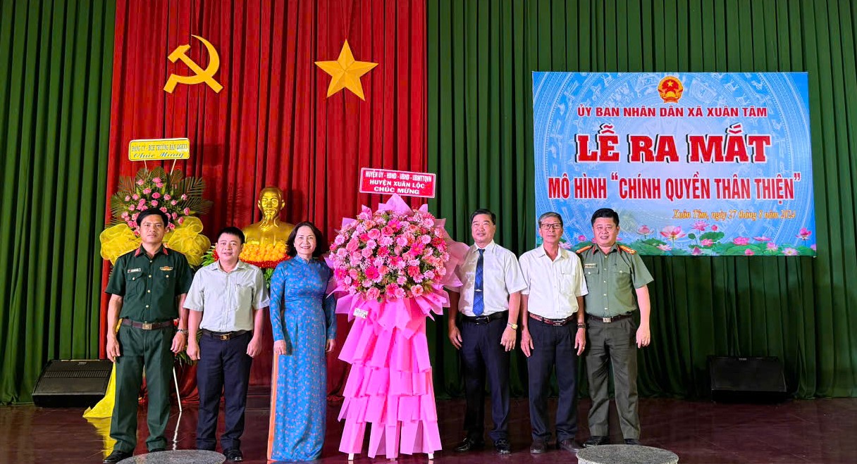 A group of people standing in front of a curtainDescription automatically generated