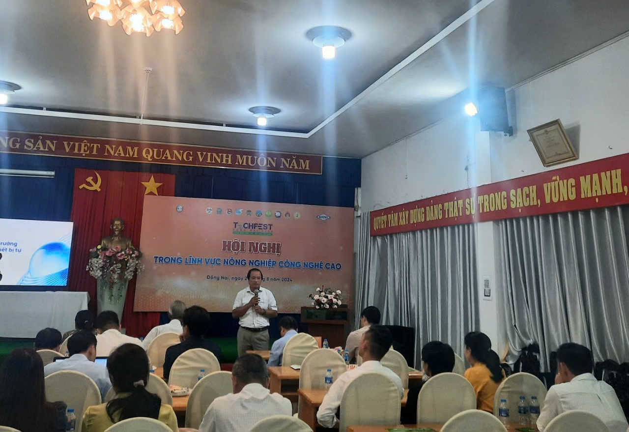 A person standing in front of a group of people sitting in chairsDescription automatically generated