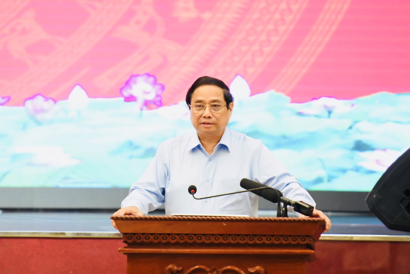 A person standing at a podium with a microphoneDescription automatically generated