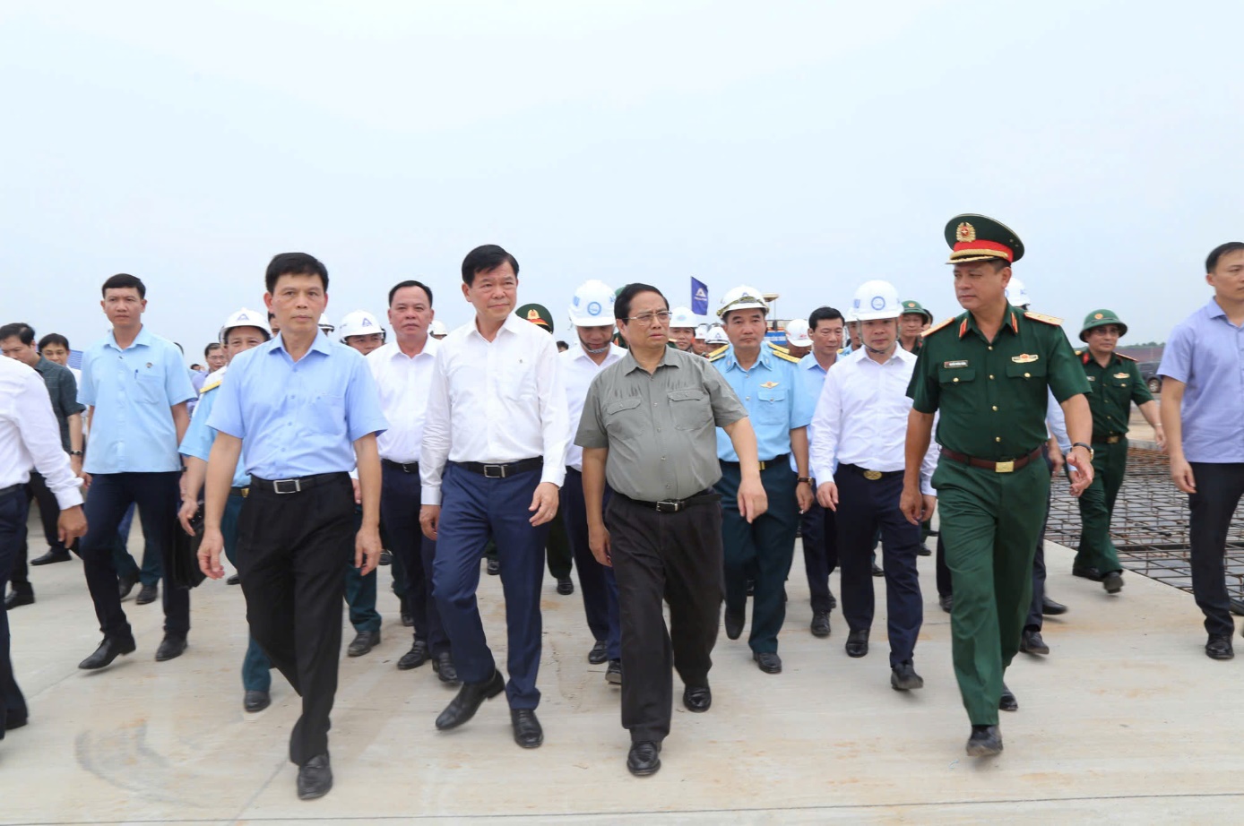 A group of men walking on a concrete surfaceDescription automatically generated