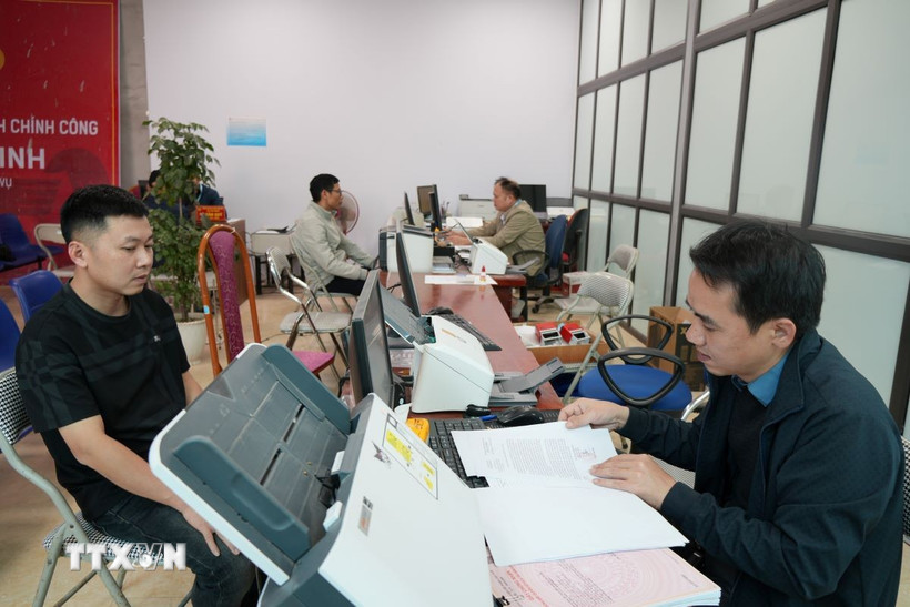 C&aacute;n bộ x&atilde; T&acirc;n Minh giải quyết thủ tục cho người d&acirc;n. (Ảnh Tiến Vĩnh/TTXVN)
