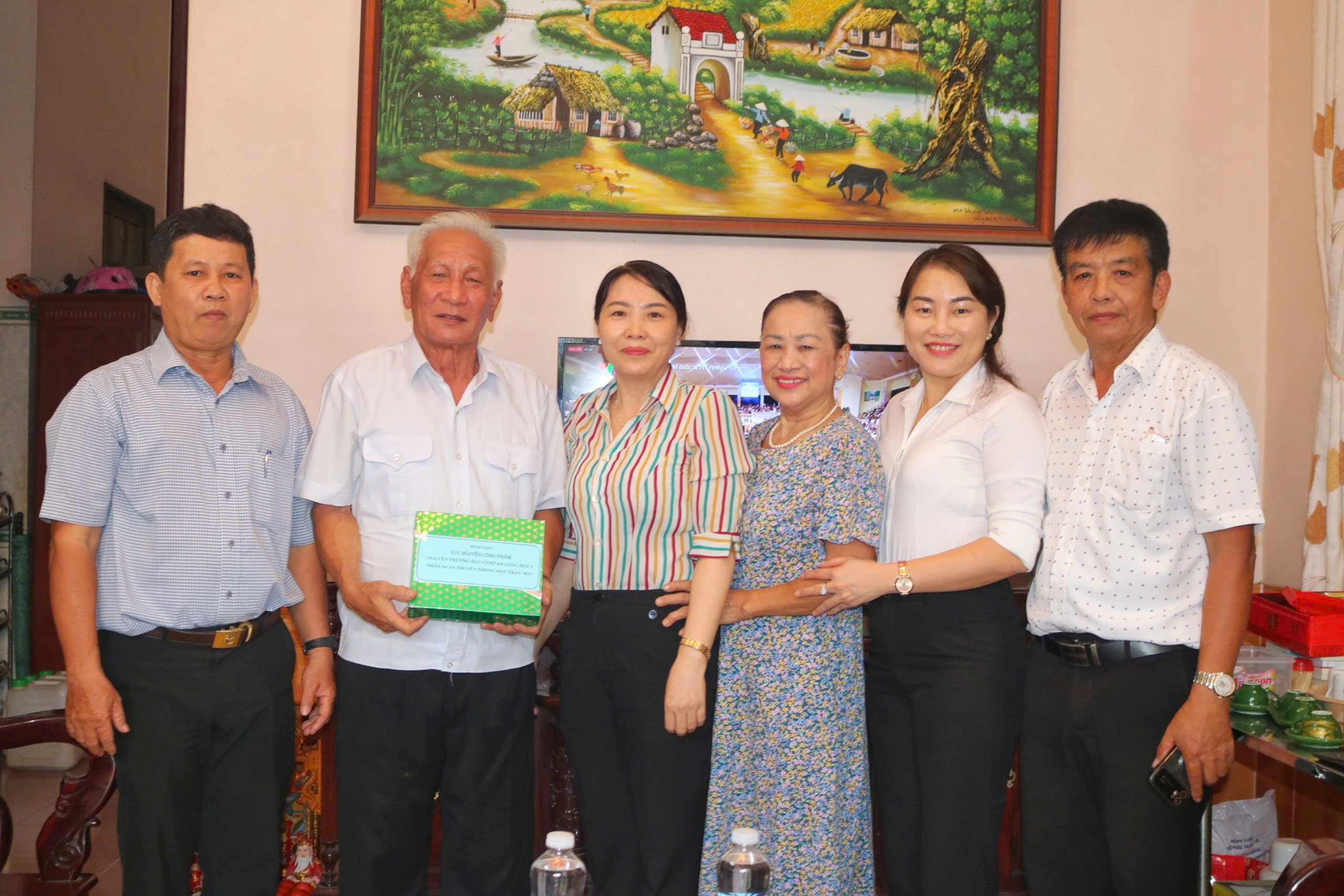 Đoàn chụp hình lưu niệm cùng đồng chí Nguyễn Công Phẩm, nguyên Trưởng Ban công tác mặt trận khu phố Long Đức 1, phường Tam Phước
