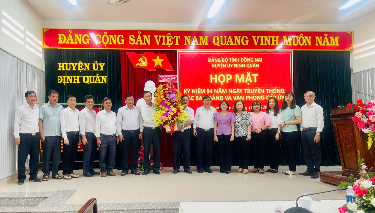 A group of people standing in front of a red bannerDescription automatically generated